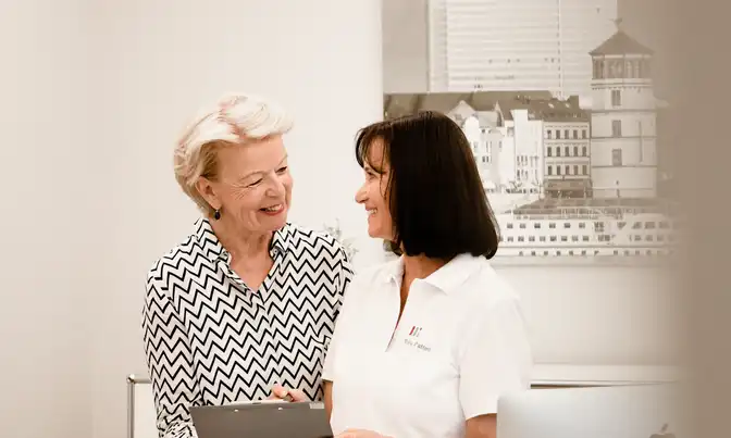 Praxismitarbeiterin im Gespräch mit einer Patientin