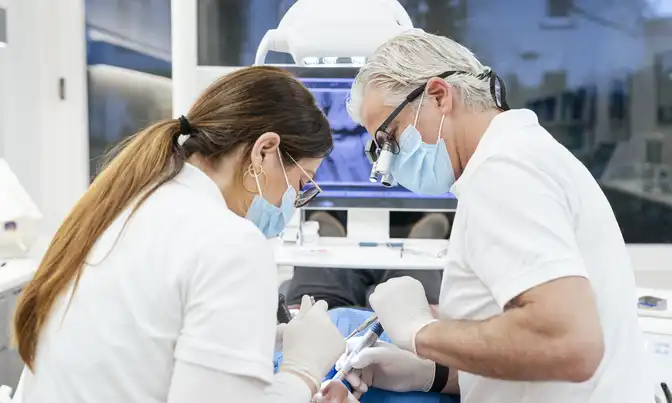 Dr. Froböse und eine Mitarbeiterin während einer Zahnbehandlung