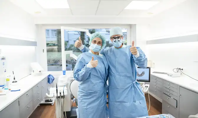 Zahnarzt Dr. Tom Froböse und eine Mitarbeiterin in OP-Kleidung