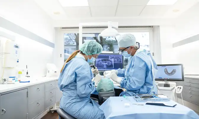 Dr. Froböse und eine Mitarbeiterin während einer Zahnbehandlung