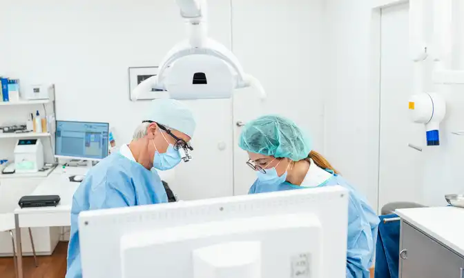 Dr. Froböse und eine Mitarbeiterin während einer Zahnbehandlung