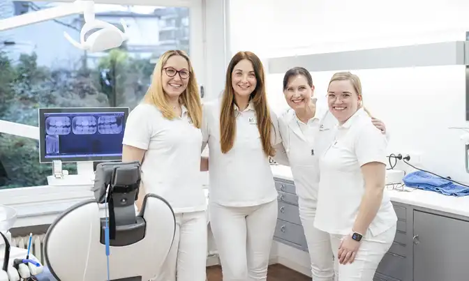 Das Team von Dr. Tom Froböse steht in einem Behandlungszimmer